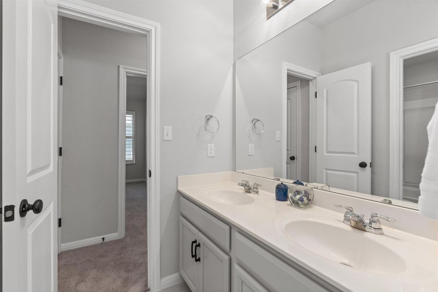 Dual sinks in the hall bathroom offer enough space for everyone.