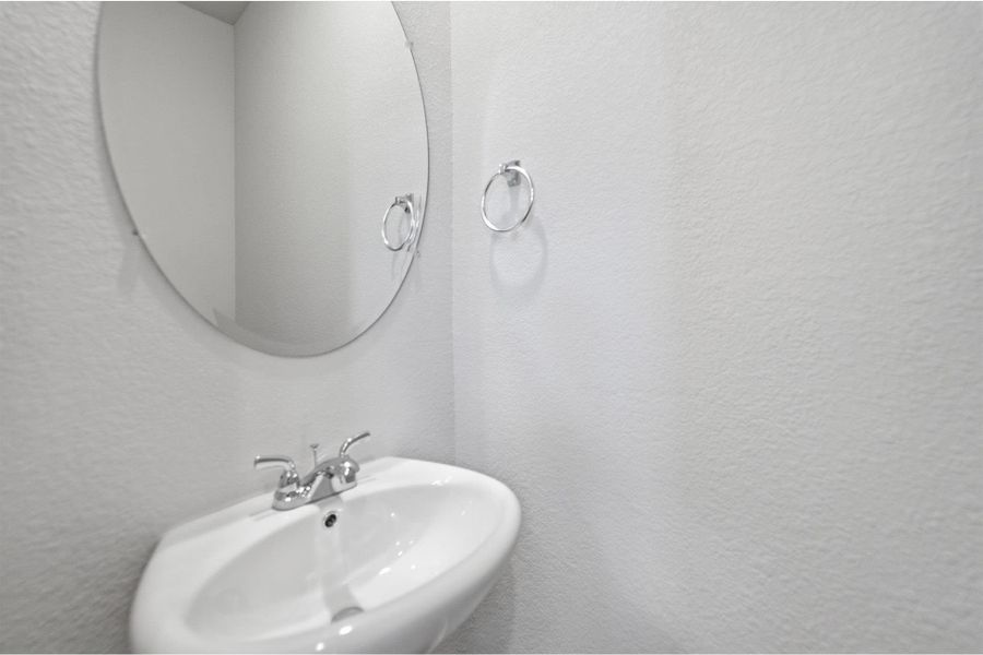 Bathroom featuring a textured wall and a sink