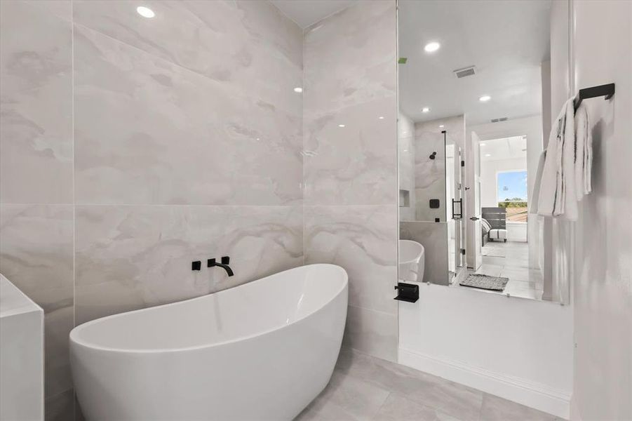 Bathroom featuring tile walls, a freestanding tub, tile patterned floors, a marble finish shower, and recessed lighting Bathroom featuring tile walls, a freestanding tub, tile patterned floors, a marble finish shower, and recessed lighting
