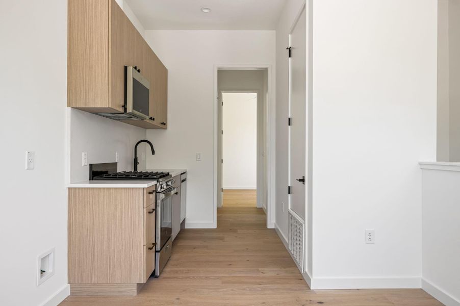 Minimalist cabinetry and sleek stone countertops define this modern, light-filled kitchen space.