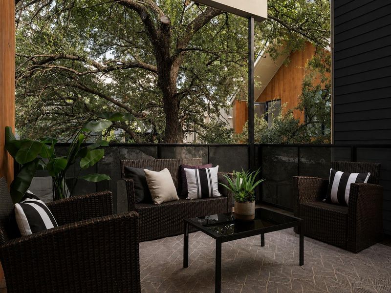 An elevated terrace offers a private outdoor retreat framed by mature trees