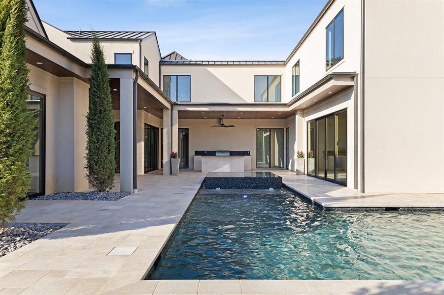 Back of house with an outdoor kitchen, ceiling fan, an outdoor pool, a patio, and a standing seam roof Back of house with an outdoor kitchen, ceiling fan, an outdoor pool, a patio, and a standing seam roof