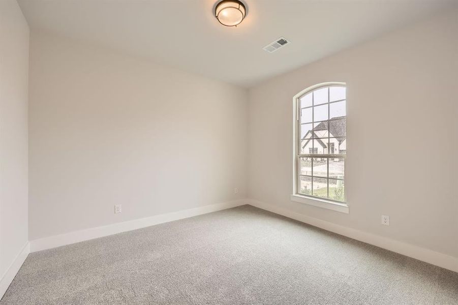 Empty room featuring baseboards, visible vents, carpet, and a healthy amount of sunlight Empty room featuring baseboards, visible vents, carpet, and a healthy amount of sunlight