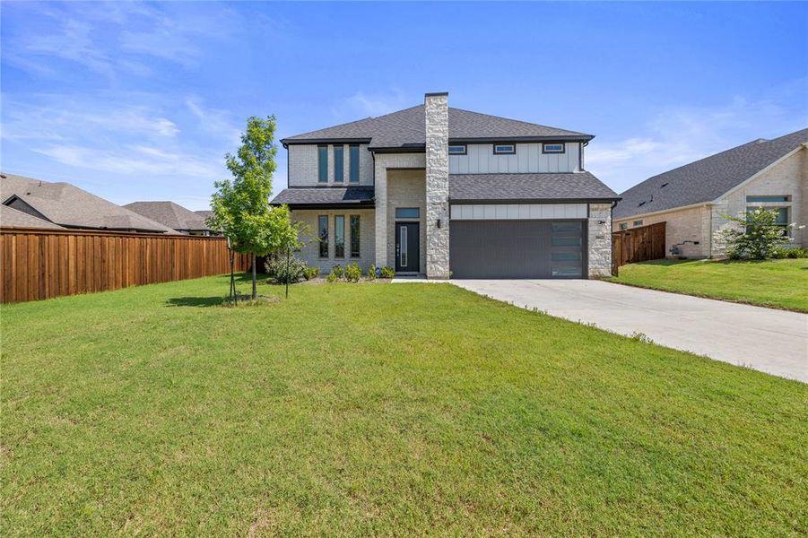 View of front of home featuring a garage and a front lawn