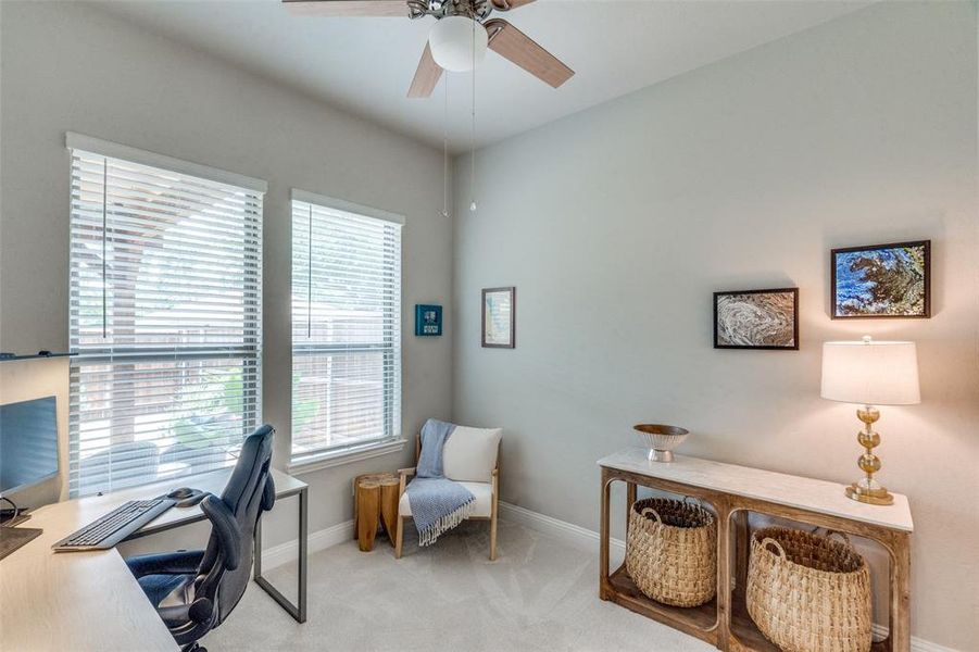 Office area with light colored carpet and ceiling fan