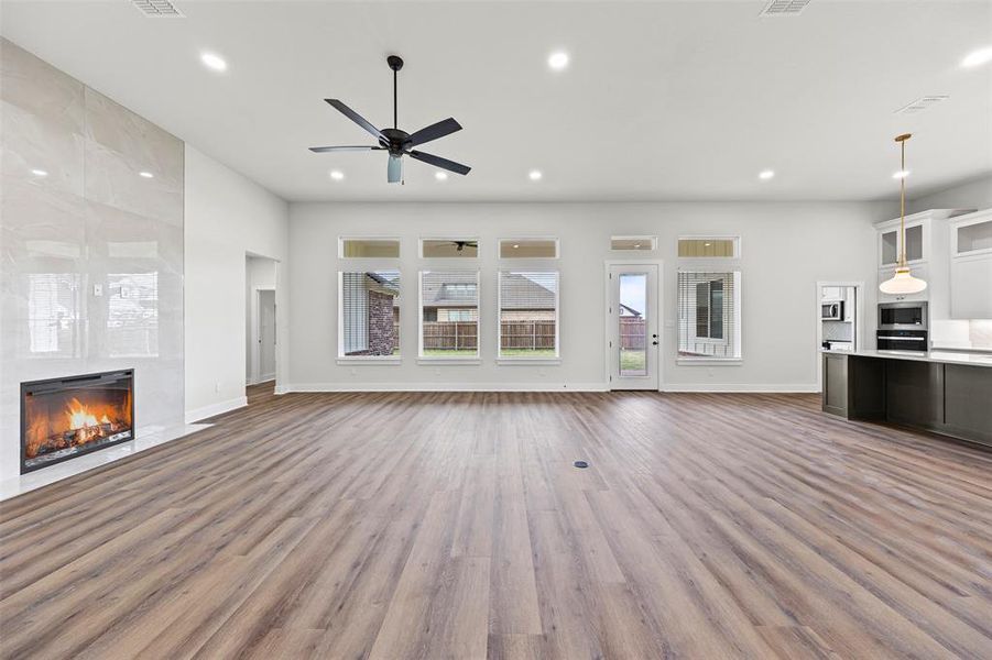 Unfurnished living room featuring dark wood finished floors, a fireplace, recessed lighting, and ceiling fan Unfurnished living room featuring dark wood finished floors, a fireplace, recessed lighting, and ceiling fan