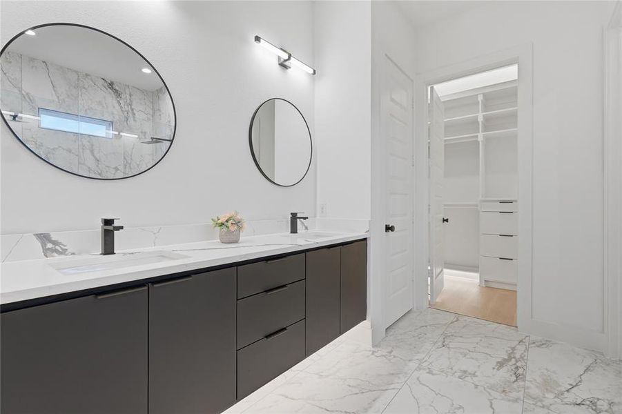 Bathroom featuring a dual vanity with dark flat-panel cabinetry, white countertops, and integrated rectangular sinks