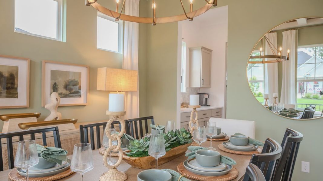 Dining area with coffered ceiling, access to kitchen, and bright natural lighting from windows Dining area with coffered ceiling, access to kitchen, and bright natural lighting from windows
