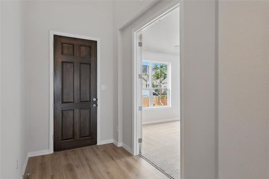 Entryway with light wood finished floors and baseboards