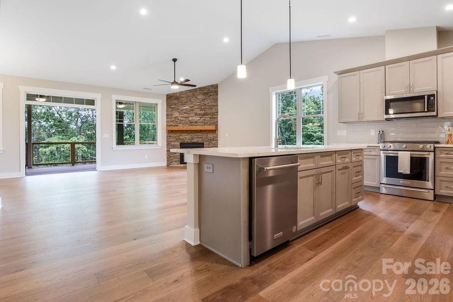 Spacious living area flows to covered Trex decking with peaceful wooded views