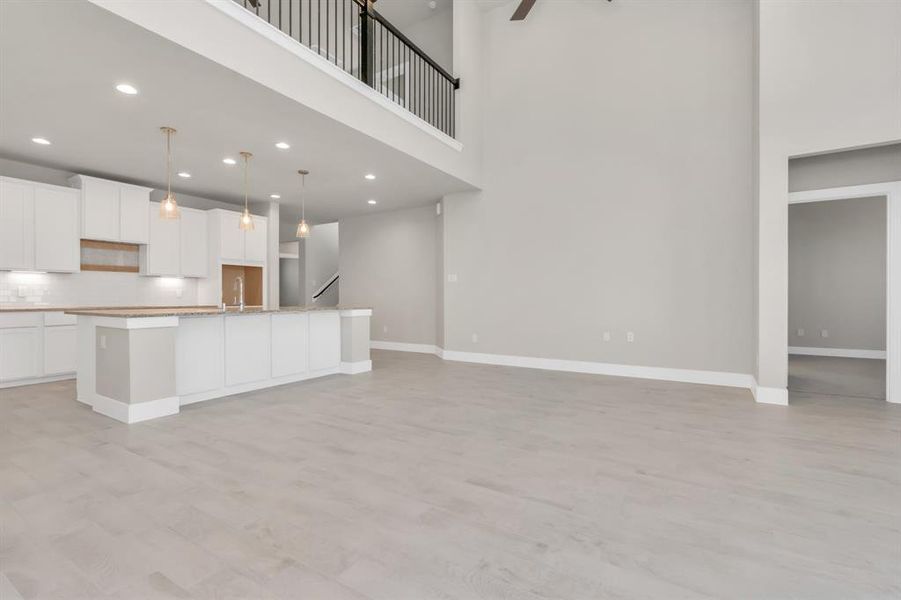 Additional view of the open and bright kitchen met by the family room. Sample photo of completed home with similar floor plan. As-built interior colors and selections may vary.