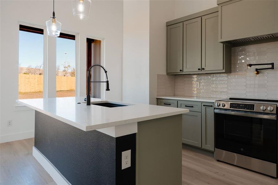 Beautiful kitchen with custom cabinetry, decorative lighting, and island seating.