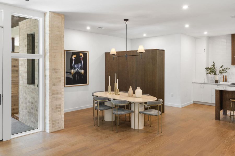 Dining area with light wood-style flooring and recessed lighting