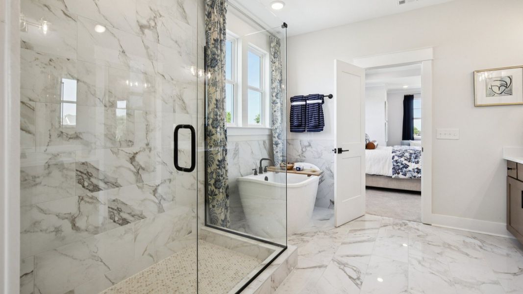 Tiled floor, free-standing tub surround, and shower with glass surround