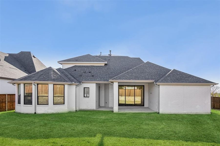 Rear view of property featuring a patio, a shingled roof, and brick siding Rear view of property featuring a patio, a shingled roof, and brick siding