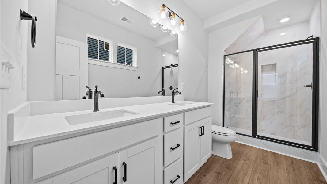 Highly functional and elegant en-suite with dual vanities, tiled walk-in shower, and refined finishes Highly functional and elegant en-suite with dual vanities, tiled walk-in shower, and refined finishes