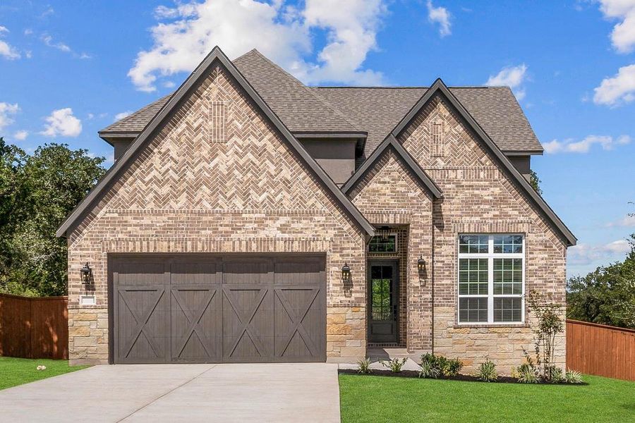 The Welch plan at The Colony is a beautiful two-story home with a long driveway, gorgeous cedar garage door, and lush front yard landscaping.