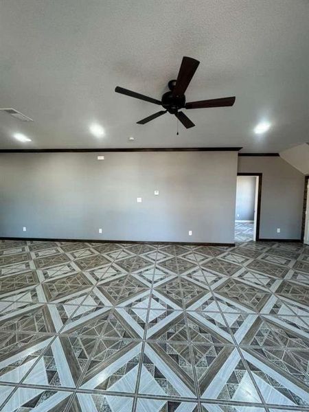 Spare room featuring a ceiling fan and a textured ceiling