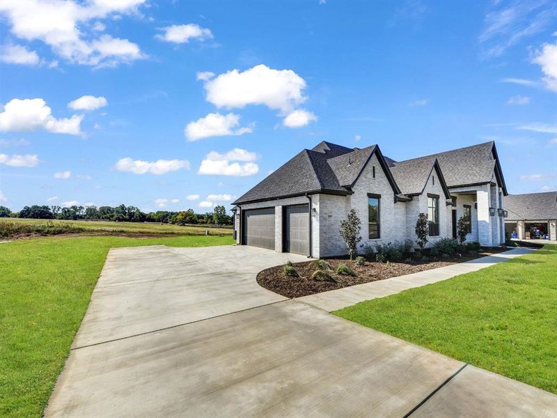 View of front of house featuring a front yard and a garage