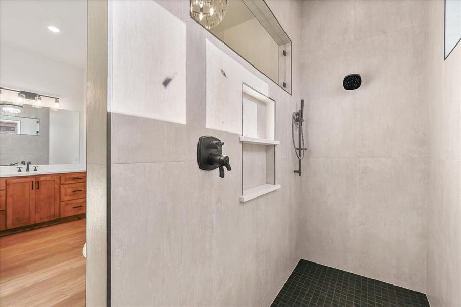 Bathroom with tiled shower and vanity