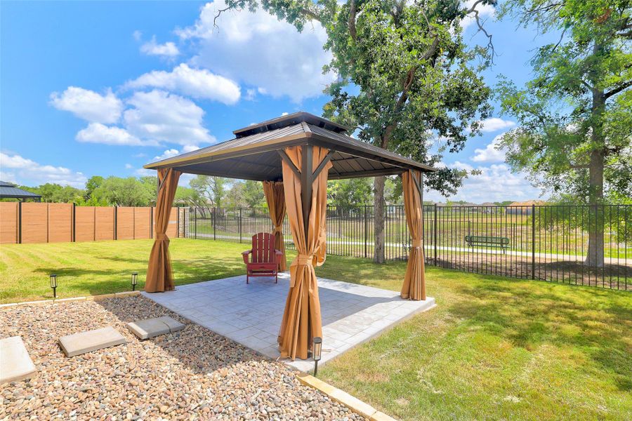 Fenced backyard featuring a gazebo and a patio area