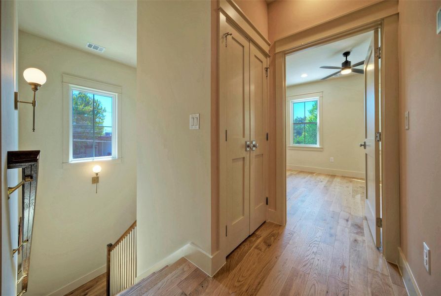 Upstairs hallway leads to three bedrooms. Here is the laundry space.