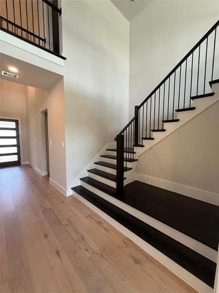 Stairs with wood finished floors and a towering ceiling Stairs with wood finished floors and a towering ceiling