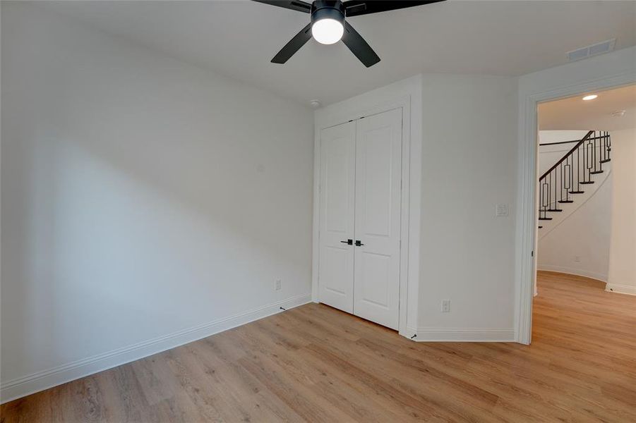 Bedroom featuring a closet, visible vents, vinyl floors, ceiling fan, and baseboards