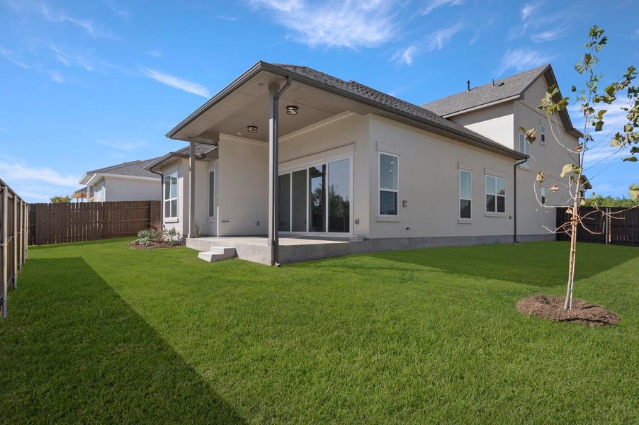 Back of house with a patio area, a fenced backyard, and stucco siding Back of house with a patio area, a fenced backyard, and stucco siding