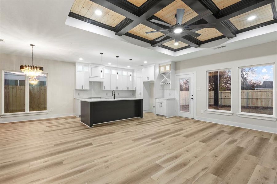 Kitchen featuring white cabinetry, coffered ceiling, open floor plan, recessed lighting, and light countertops