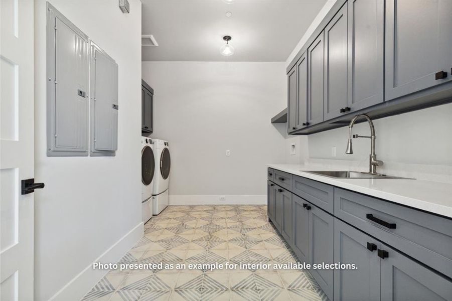 Laundry room with cabinets, sink, washing machine and dryer, and light tile flooring