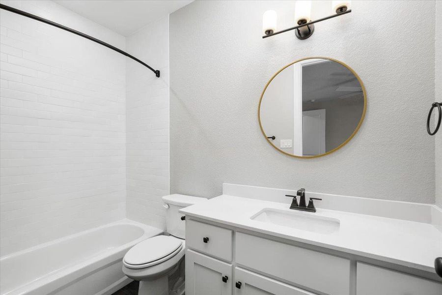 Full bathroom with vanity, toilet, and shower / tub combination Full bathroom with vanity, toilet, and shower / tub combination