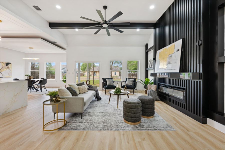 Living area with light wood-type flooring, ceiling fan, a glass covered fireplace, and recessed lighting Living area with light wood-type flooring, ceiling fan, a glass covered fireplace, and recessed lighting