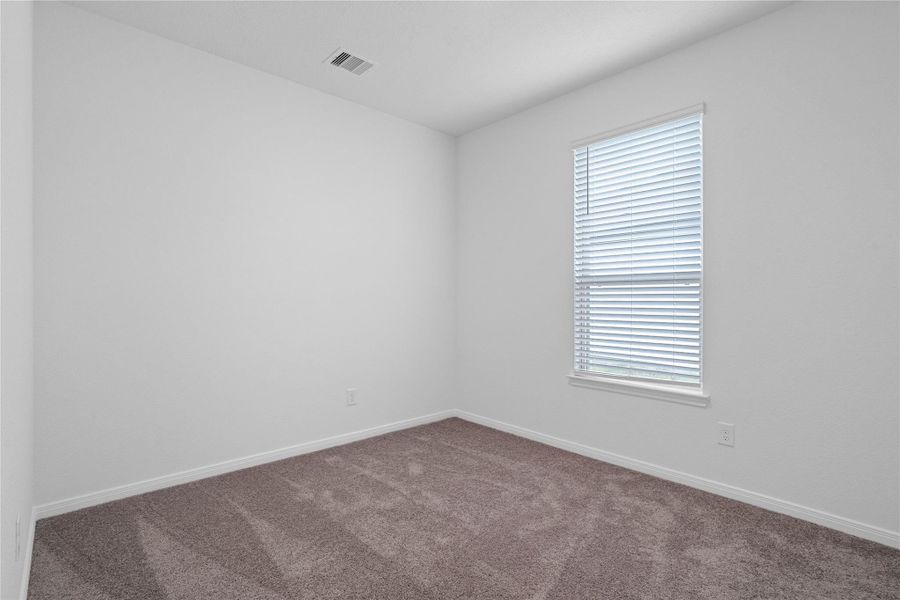 This secondary bedroom offers comfort and style with plush carpeting, neutral paint tones, a large window fitted with blinds, and a generously sized closet. This secondary bedroom offers comfort and style with plush carpeting, neutral paint tones, a large window fitted with blinds, and a generously sized closet.