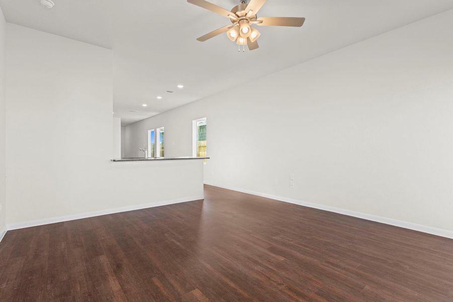 Expansive open concept living area that flows effortlessly into the kitchen and dining spaces. High ceilings, vinyl plank flooring, and bright natural light make this area perfect for everyday living and entertaining. Expansive open concept living area that flows effortlessly into the kitchen and dining spaces. High ceilings, vinyl plank flooring, and bright natural light make this area perfect for everyday living and entertaining.