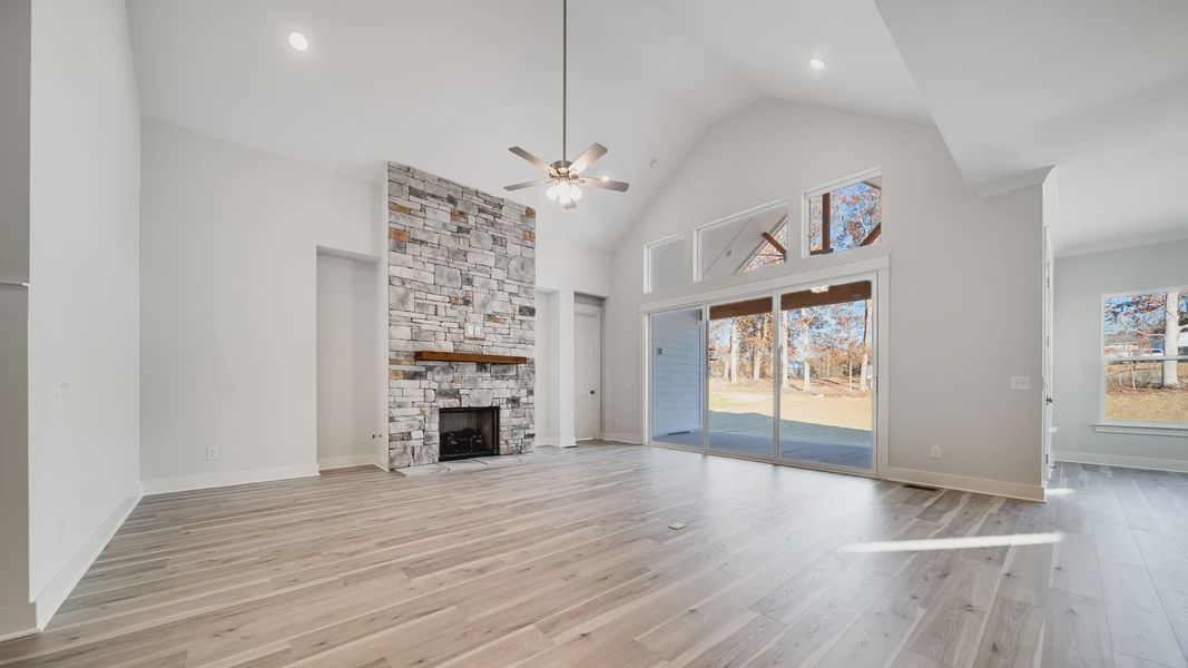 Large living room area with vaulted ceiling and stone fireplace