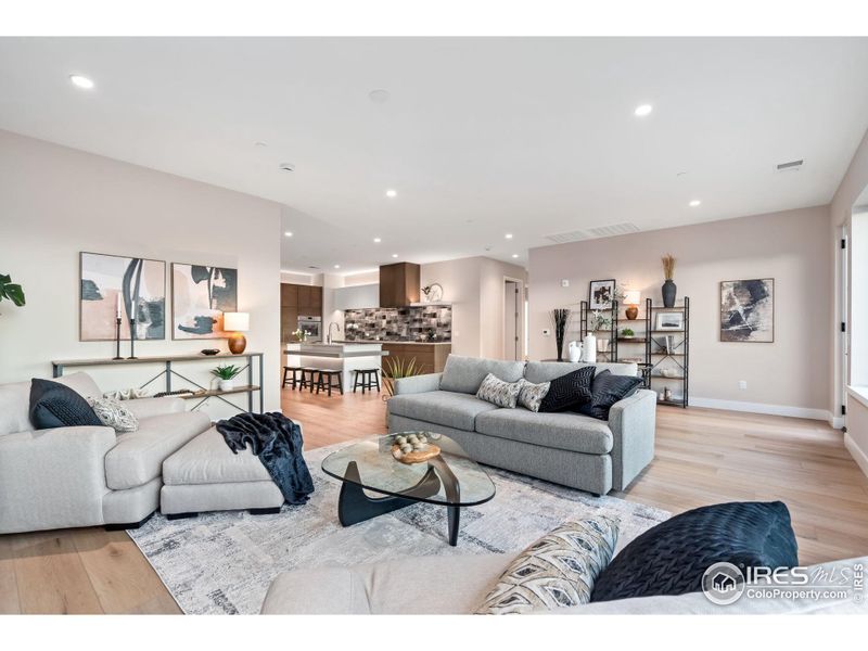 A HUGE combined living/dining space looks right out to the Rocky Mountains, above rooftops.