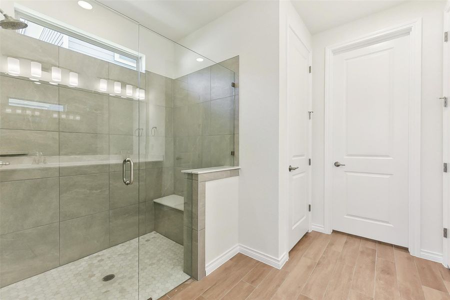 Bathroom with baseboards, a stall shower, and wood finished floors Bathroom with baseboards, a stall shower, and wood finished floors