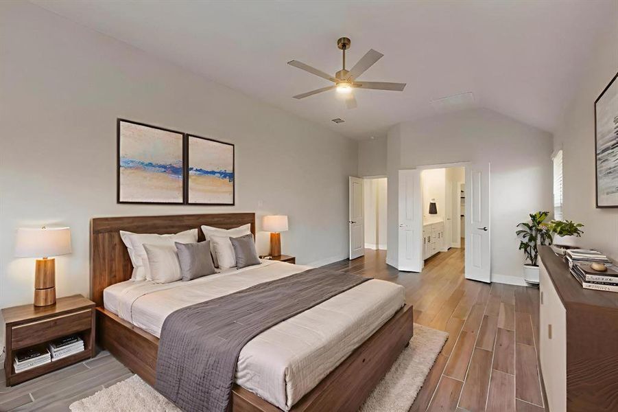 Bedroom with wood finish floors, a ceiling fan, ensuite bathroom, and lofted ceiling
