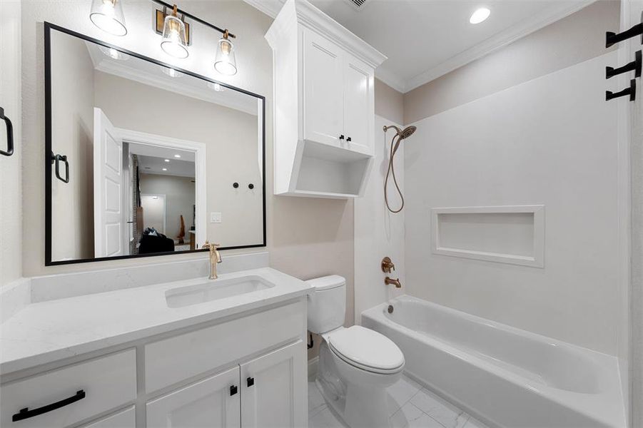 Ensuite bathroom with crown molding, shower / washtub combination, vanity, toilet, and marble finish floor
