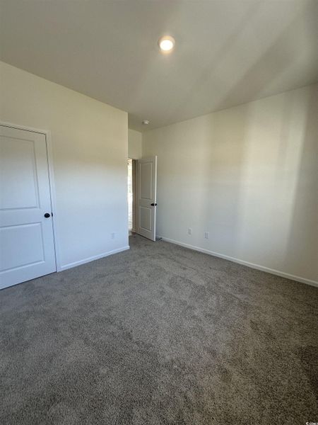 Carpeted spare room featuring baseboards