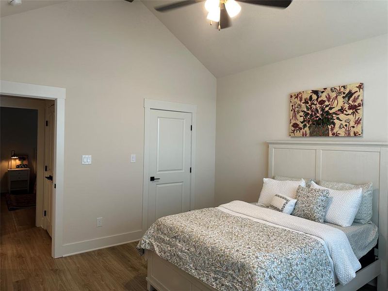 Vaulted ceiling room featuring wood-finish flooring