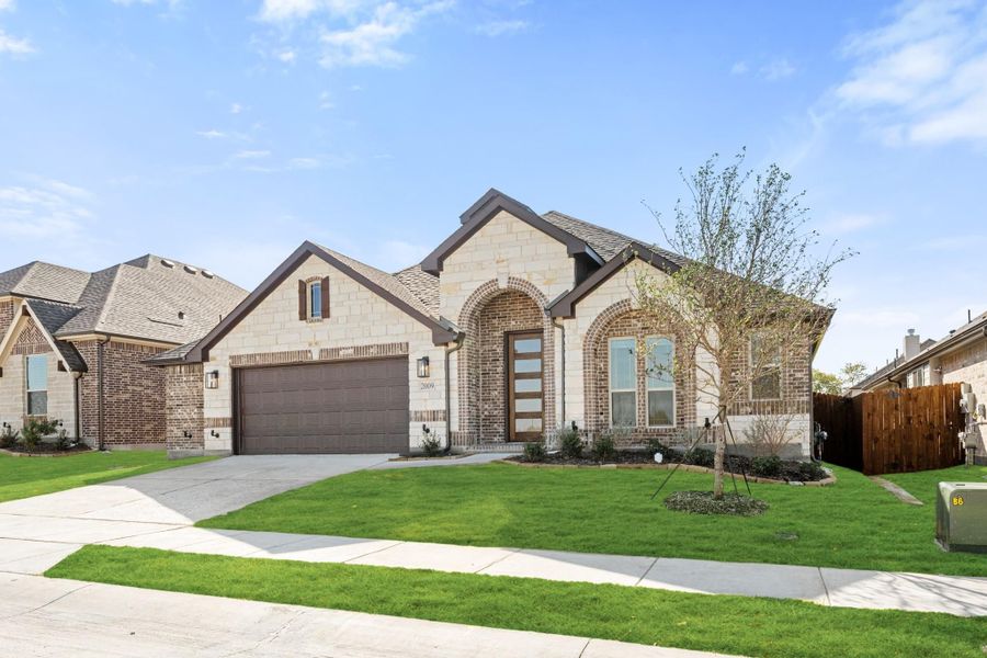 Single-story home with stone and brick exterior, two-car garage, and arched entryway with green lawn
