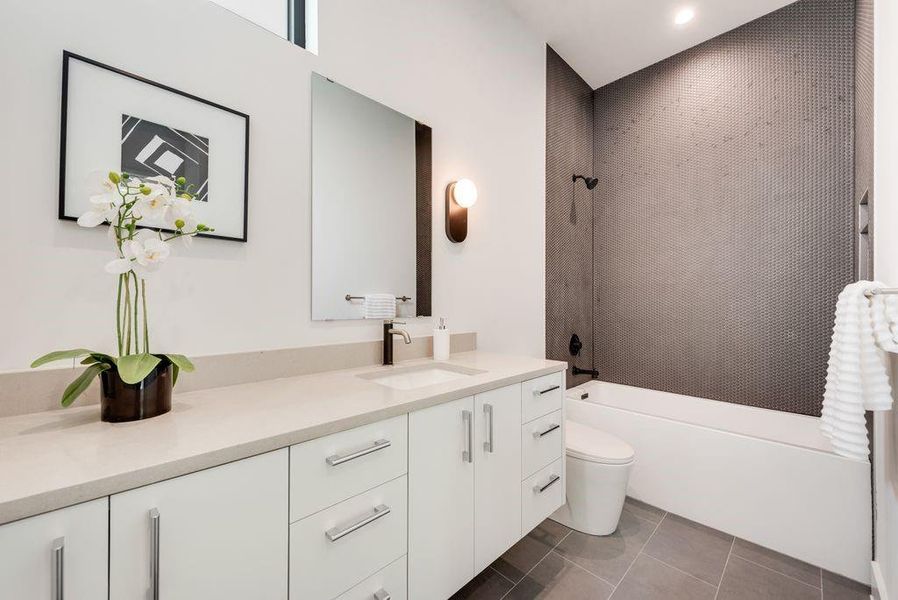 Full bath with elevated design palette and walk-in closet.