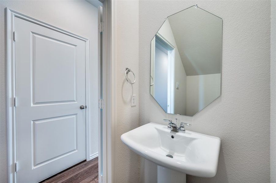 Bathroom featuring lofted ceiling, wood-type flooring, and sink