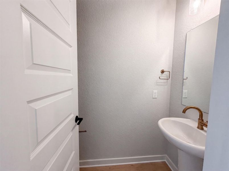 A compact and functional bathroom features a modern pedestal sink and elegant bronze fixtures. A compact and functional bathroom features a modern pedestal sink and elegant bronze fixtures.