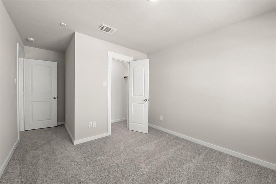 Secondary Bedroom with a walk in closet.