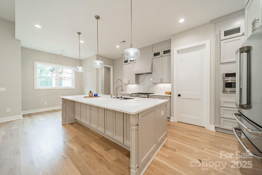 Fabulous Chef's Kitchen with oversized Gas Range and Oven, Quartz Counter Tops and Backsplash, and Custom Cabinetry