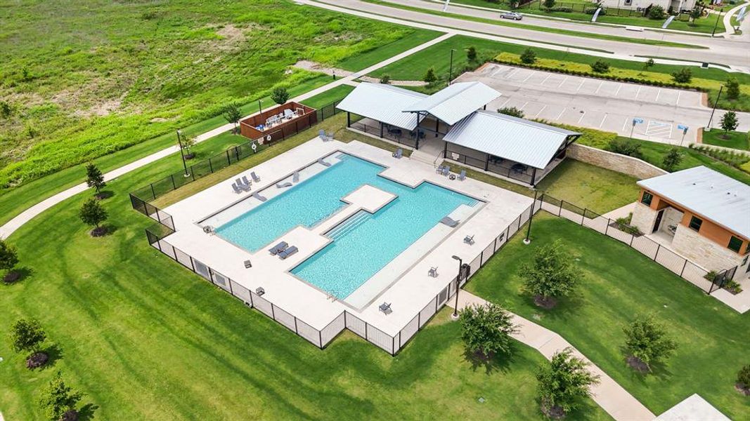 Community pool area featuring multiple swimming pools, extensive surrounding hardscaping, a covered pavilion structure, manicured green spaces, and a nearby structured building Community pool area featuring multiple swimming pools, extensive surrounding hardscaping, a covered pavilion structure, manicured green spaces, and a nearby structured building