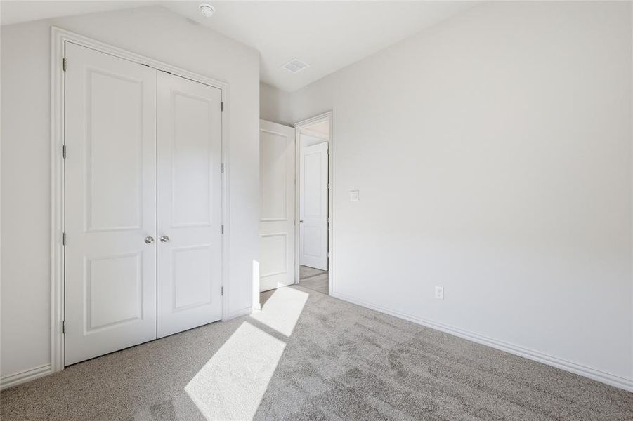 Unfurnished bedroom with carpet flooring and a closet Unfurnished bedroom with carpet flooring and a closet